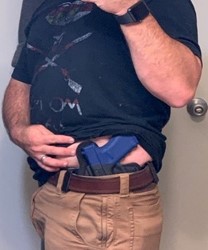 Side view of a concealed weapon with the shirt pulled up, exposing the weapon