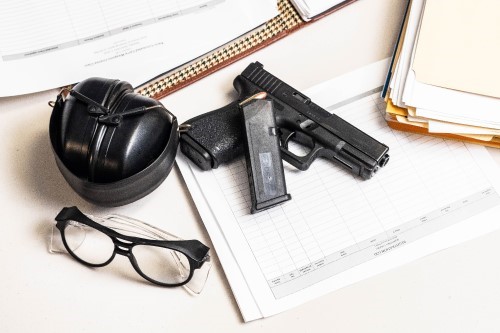 Firearms gear sitting on a desk with papers and file folders