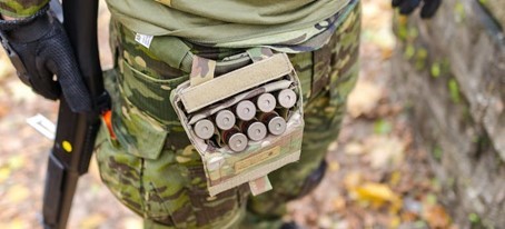 close-up of bullets in senior man's sport shooting equipment